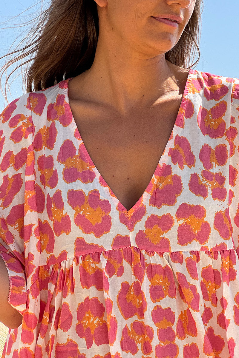 Ayelen - Vestido blanco de corte fluido con estampado de leopardo en rosa y naranja, cuello en V y mangas holgadas